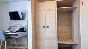 Una habitación con escritorio, silla y armario de dos puertas.
