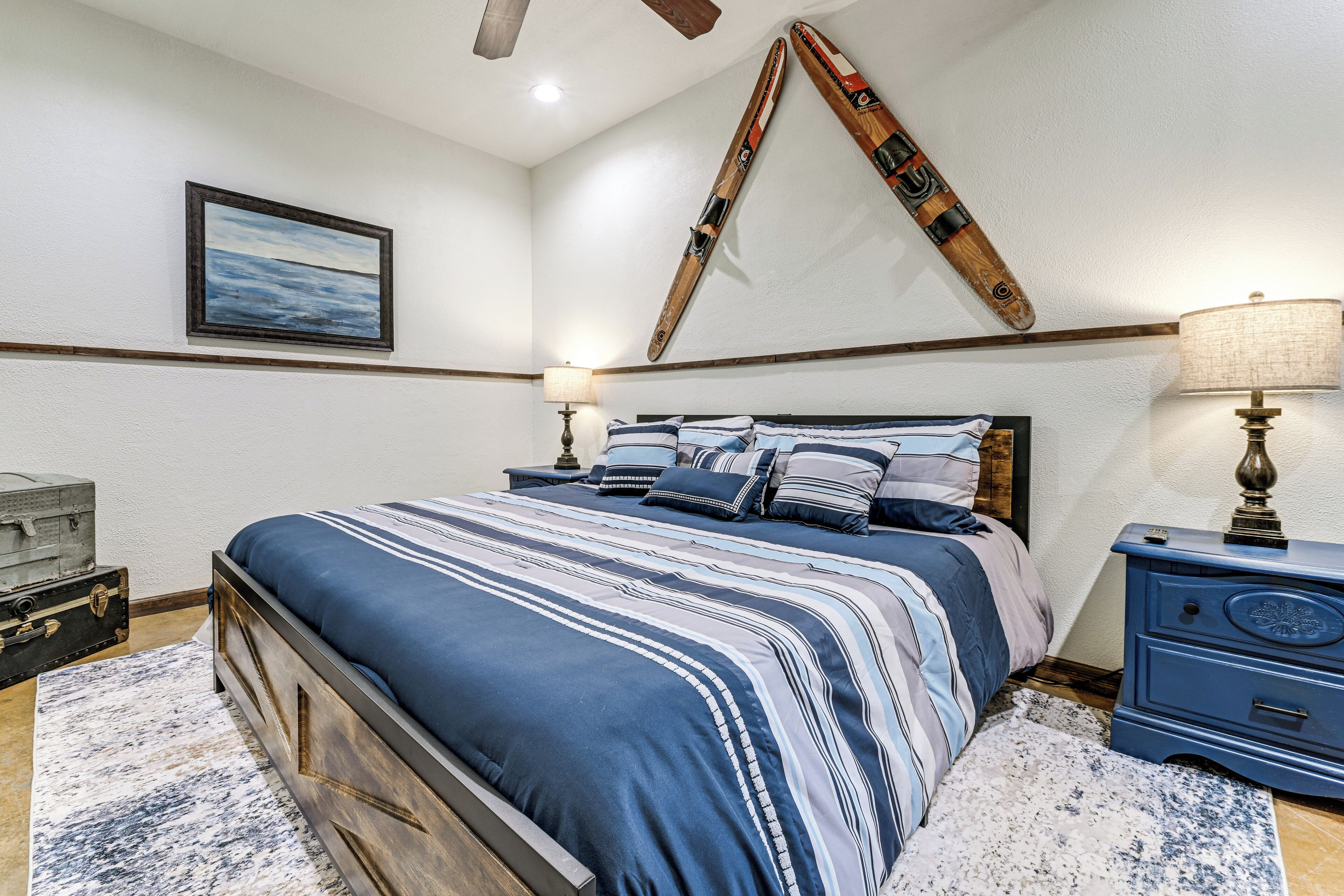 Ein Schlafzimmer mit Bett, Nachttisch, Lampe, einem Bild und einem Ski an der Wand.