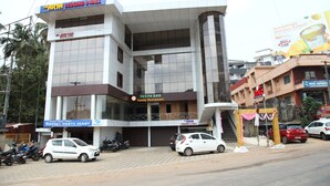 A multi-story building with a family restaurant, a parts store, and a hotel. - Sai Arya Lodging & Hall (Mangaluru)