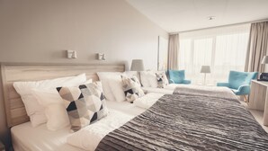 Una habitació d'hotel amb un llit gran, dues taules de nit, un escriptori i una cadira.