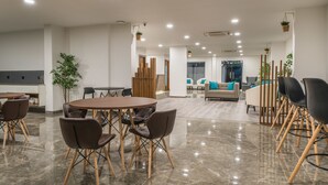 Un espacio interior moderno con una mesa redonda y sillas, un sofá y una mesa de centro.