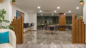 Un espacio de oficina moderno con una mesa de reuniones, sillas y un sofá.