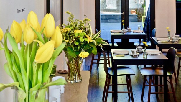 Un restaurant doté d’une salle à manger, d’un mur orné de texte et d’une vue sur l’extérieur, visible à travers une porte vitrée.