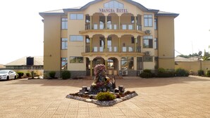 La façade extérieure de l’hôtel NBangba, avec sa cour centrale et une sculpture décorative.