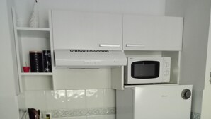 A compact kitchen with a stove, microwave, and refrigerator. - T2 curists classified 3 * Res secure 10 minutes walk from the thermal baths (Lamalou-les-Bains)