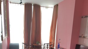 Een kamer met een groot bed, een bureau, een stoel en een klein tafeltje.