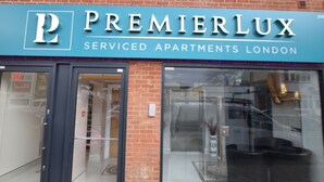 Um edifício com uma placa que diz 'Premierlux Serviced Apartments London'.