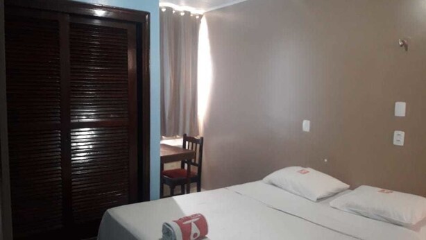 Une chambre d’hôtel avec un lit, un bureau et une chaise.