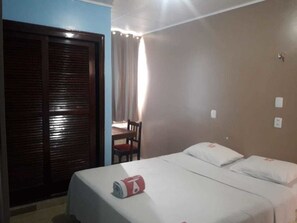 Ein Hotelzimmer mit Bett, Schreibtisch und Stuhl.