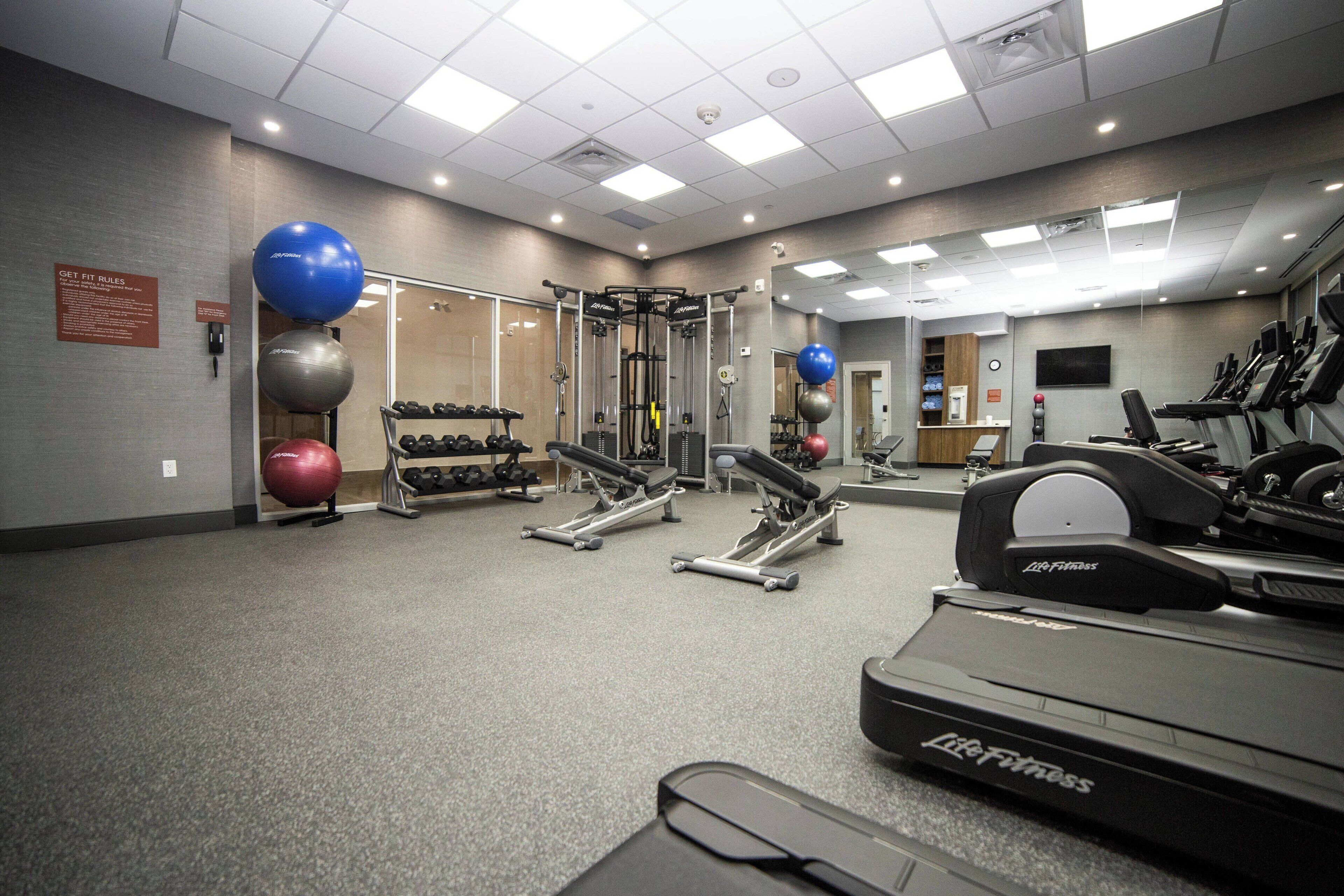 A gym with cardio equipment, weight machines, and free weights.