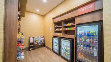 Un espace dédié à la vente de collations et de boissons, équipé de plusieurs étagères et de réfrigérateurs.