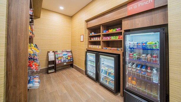 Zona de venta automática de aperitivos y bebidas, con varias estanterías y congeladores.