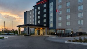 A modern hotel with a sign reading "Towneplace Suites by Marriott" and a flag on the building. - TownePlace Suites by Marriott Brantford and Conference Centre (Brantford)