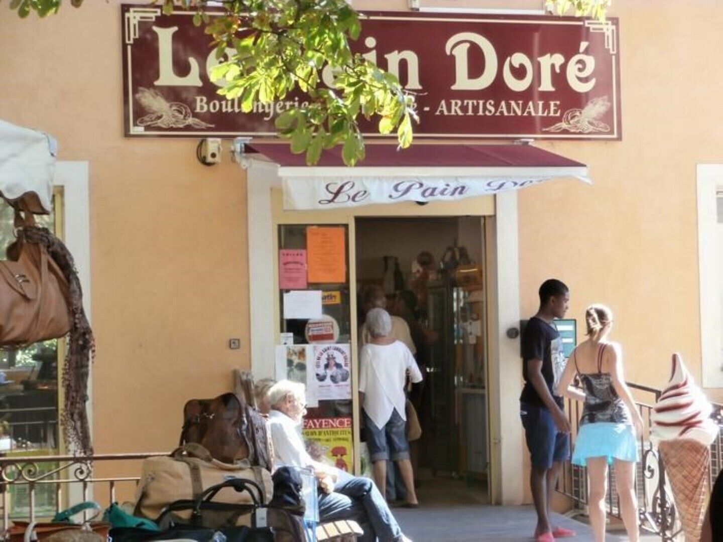 Una vetrina con un'insegna che dice "Le Pain Doré" e uno striscione che recita "Le Pain Gourmand".