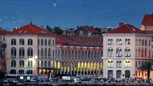 A waterfront building with arched windows and a red roof. - Mama's and Papa's Luxury Rooms (Split)