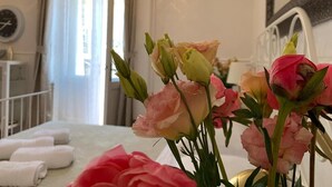 A hotel room with a bed, a bedside table with towels, and a window with curtains. - Mama's and Papa's Luxury Rooms (Split)