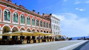 A historic building with a row of outdoor seating and a paved plaza. - Mama's and Papa's Luxury Rooms (Split)