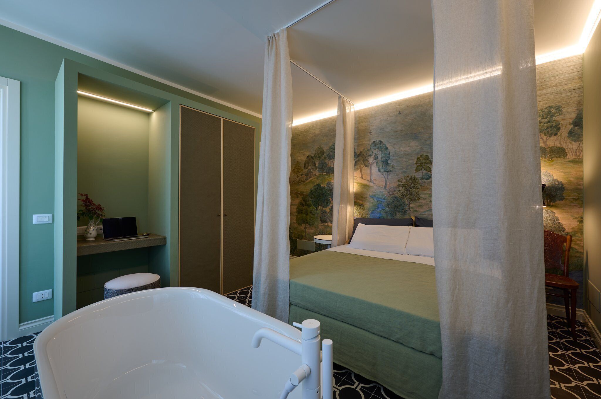 Ein Schlafzimmer mit einem großen Bett, einer Badewanne und einer Wand mit einem Wandgemälde zum Thema Natur.