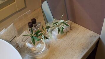 A bathroom with a marble countertop, a mirror, and two bottles of hand soap.