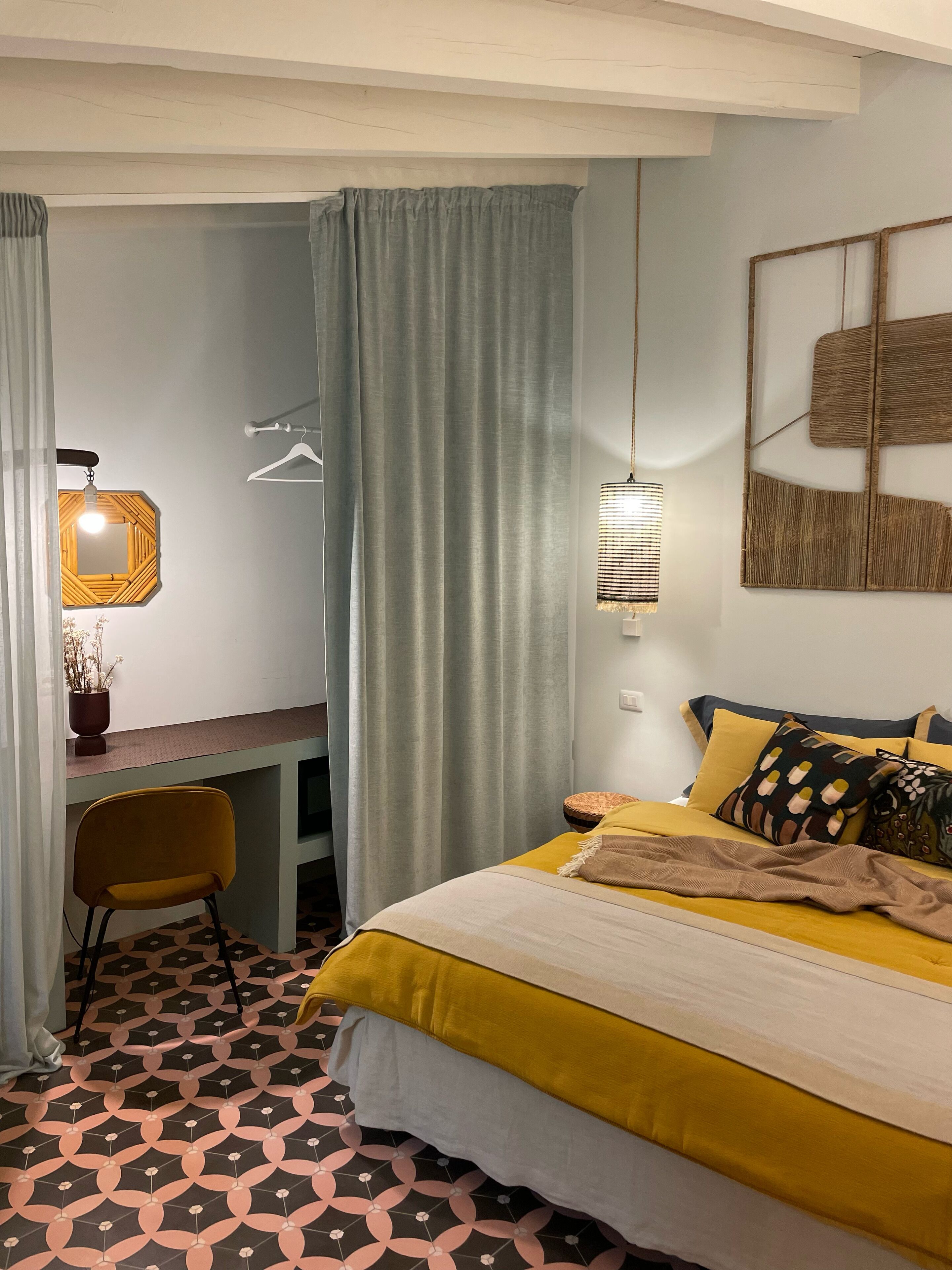 A bedroom with a bed, a desk, and a chair.
