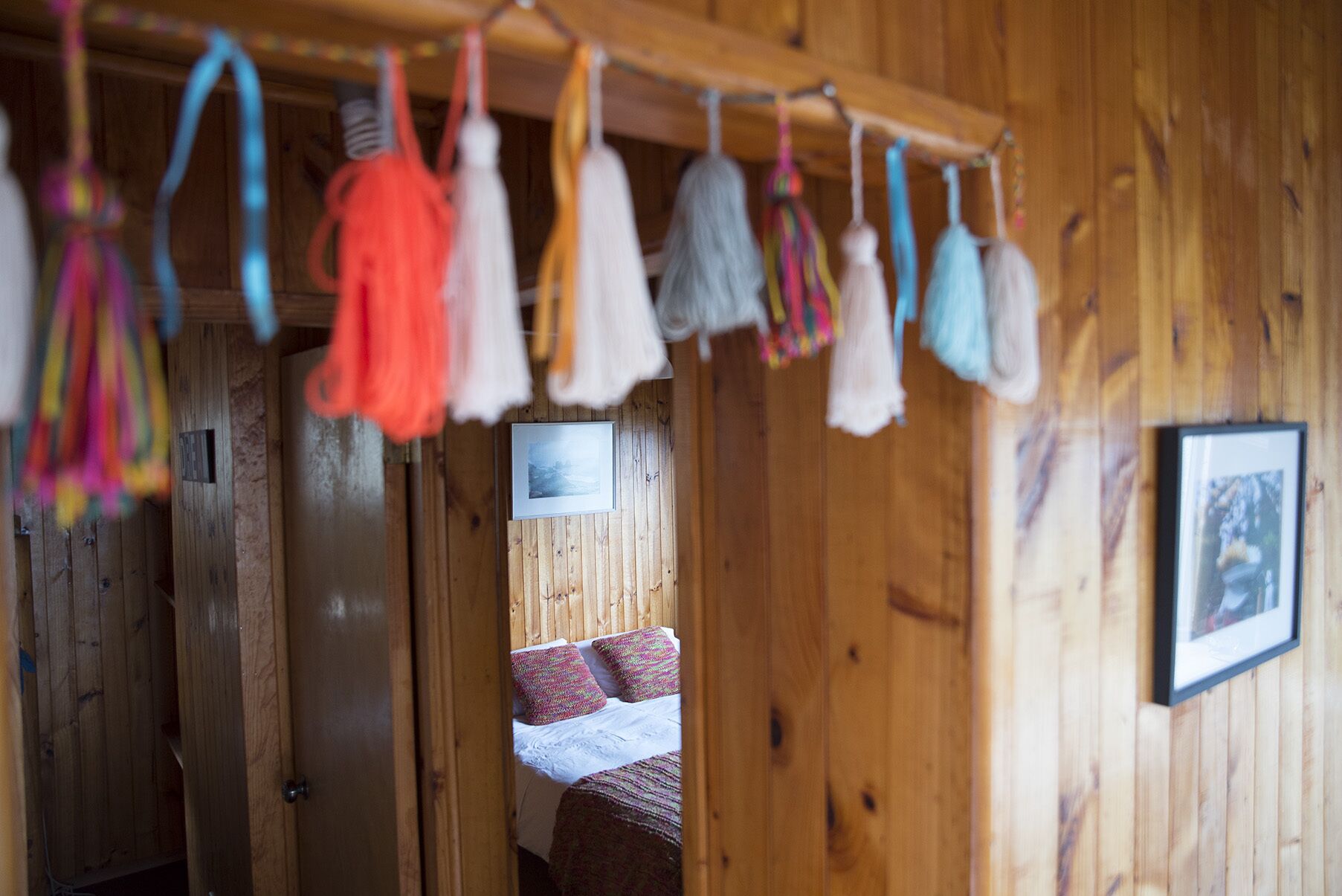 Un interior de madera con una cama y un adorno colgante.