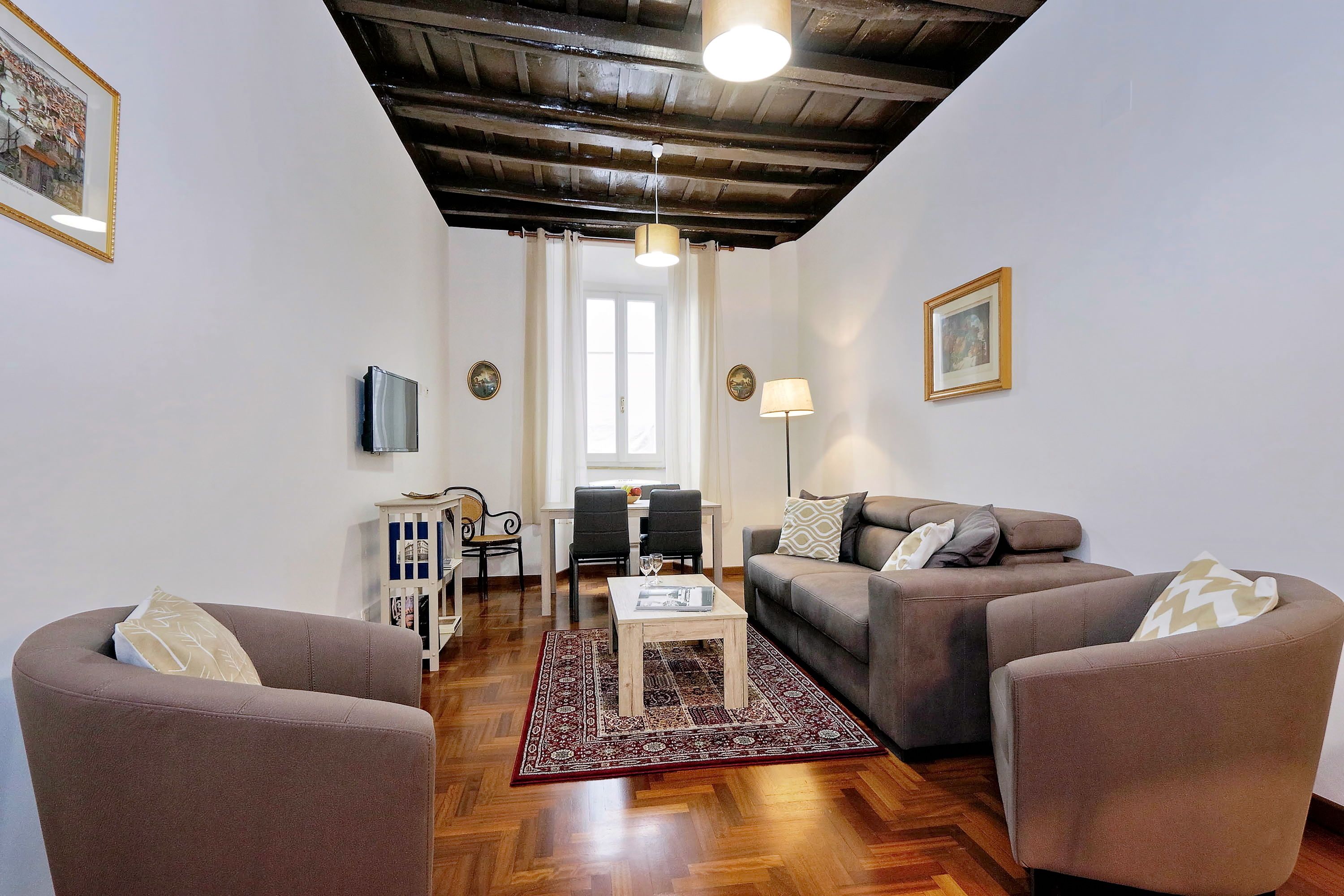 A living room with two sofas, a coffee table, and a dining area with chairs and a table.