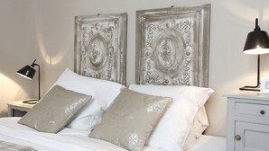 A neatly made bed with two pillows, a bedside lamp, and a nightstand with a lamp. - Nature & Chateaux à Chinon (Chinon)