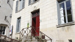 A historic building with a red door, stone steps, and a metal railing. - Nature & Chateaux à Chinon (Chinon)