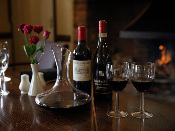 A bar setting with wine bottles and glasses on a wooden table.