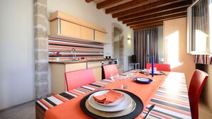 A dining area with a long table set for four, featuring striped tablecloths and red chairs. - Residence Cala Paura - Vecchio Frack (Polignano a Mare)