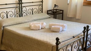 Un lit bien fait, avec une couvre-lit matelassé et deux serviettes enroulées posées sur le lit.