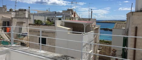Zona residencial costera con varios edificios, algunos con balcones, y una vista despejada del mar.