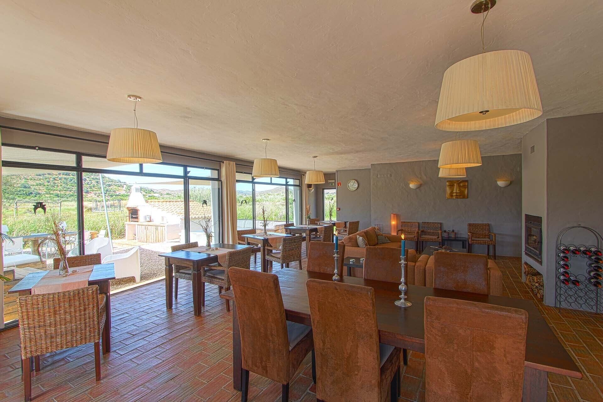 A spacious dining area with high ceilings and large windows offering a view of the outdoors.