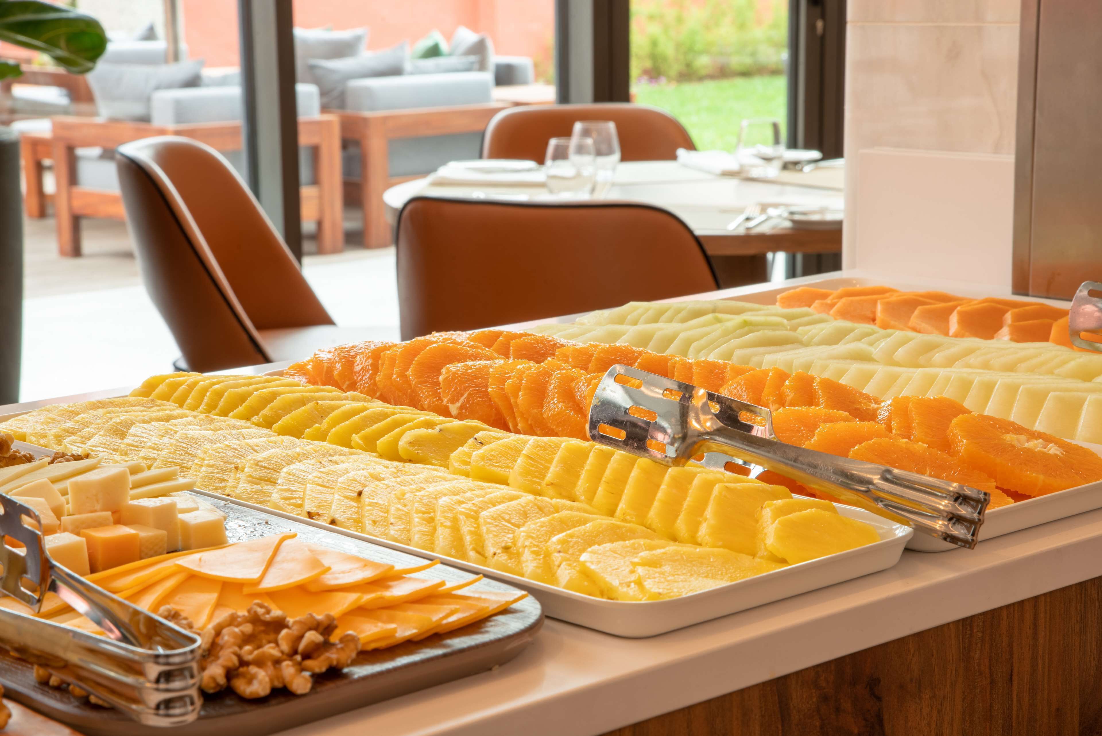 Ein Buffet mit verschiedenen Speisen, darunter Käse, Früchte und Nüsse.