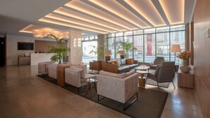 Un vestíbulo amplio con muebles modernos, ventanas grandes y un diseño de techo bien iluminado.