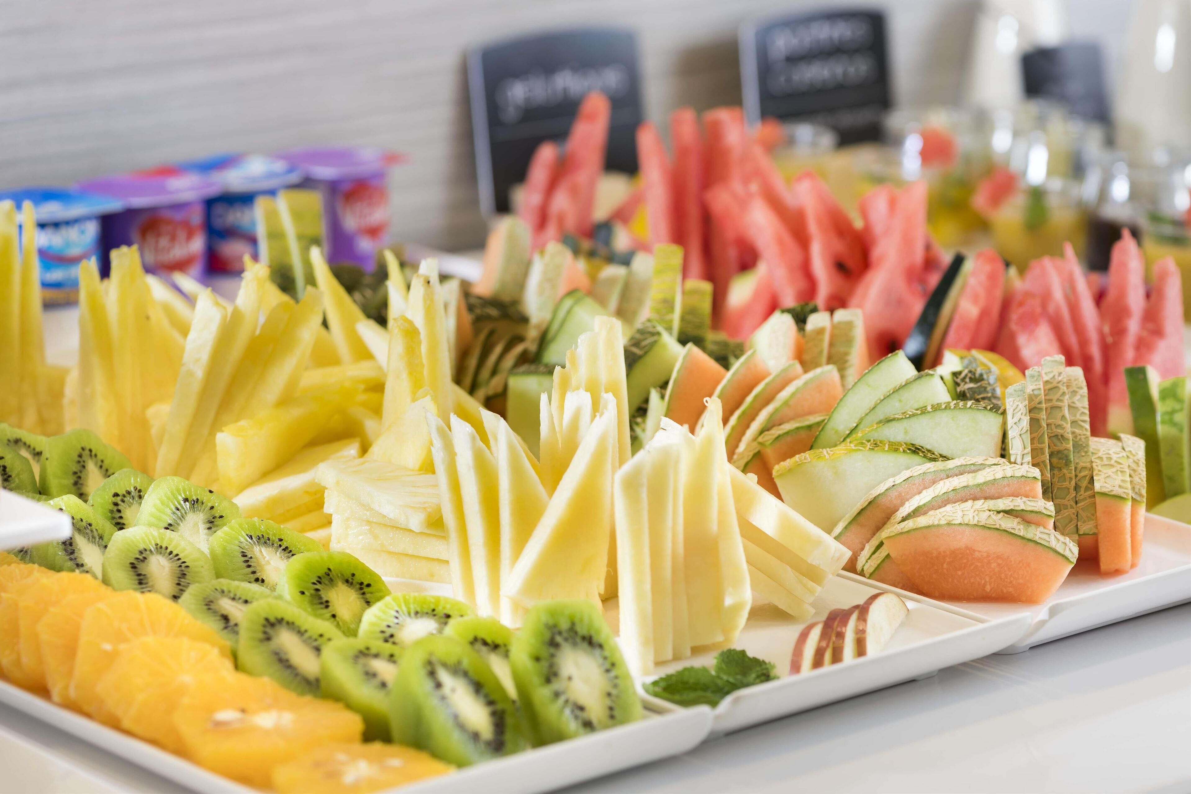 A fruit platter with various sliced fruits and vegetables.