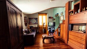 A living room with a wooden cabinet, a sofa, a television, and a wooden cabinet with drawers. - Entire apartment with Cathedral view, 2 bedrooms and 2 bathrooms, fully equipped (Palermo)