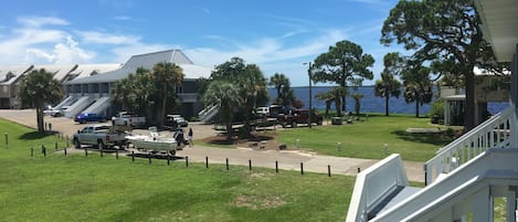 A coastal property with a grassy lawn, a boat dock, and a view of the sea.