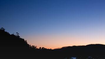 Silueta de un paisaje montañoso al anochecer con cielo despejado.