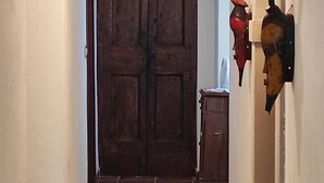 A hallway with a wooden door, a small cabinet, and a wall-mounted object. - Romantic tower house with swimming pool (Ravenna, Bologna, Florence) (Casola Valsenio)