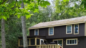 A two-story house with a deck and a hammock. - Waterfront Lakehouse (Stetson)