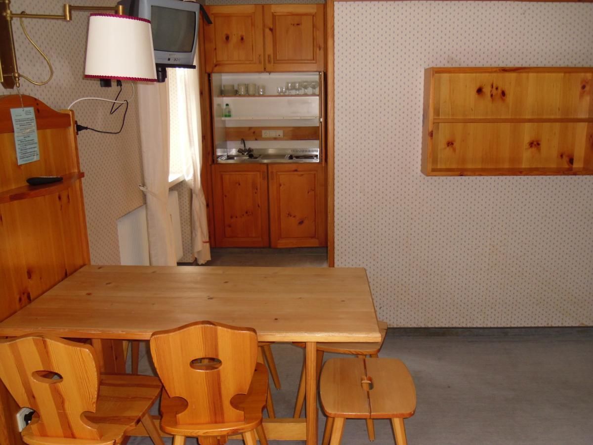 A kitchen with wooden cabinets, a built-in microwave, and a dining table with chairs.