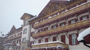 Una hilera de edificios tradicionales de varios pisos con balcones, cubiertos de nieve.