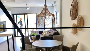 A modern dining area with wicker furniture, a round table, and decorative vases. - Cabopino (Marbella)