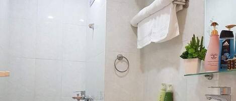 Een badkamer met toilet, wastafel en douche.