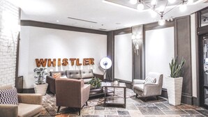 A modern lobby with a sofa, armchairs, a coffee table, and a potted plant. - Pet-Friendly | Whistler | Shuttle, Pool + Hot Tub (Whistler)