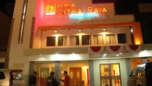 Un hôtel appelé « Hotel Citra Raya », doté d’une façade moderne et d’une enseigne lumineuse.