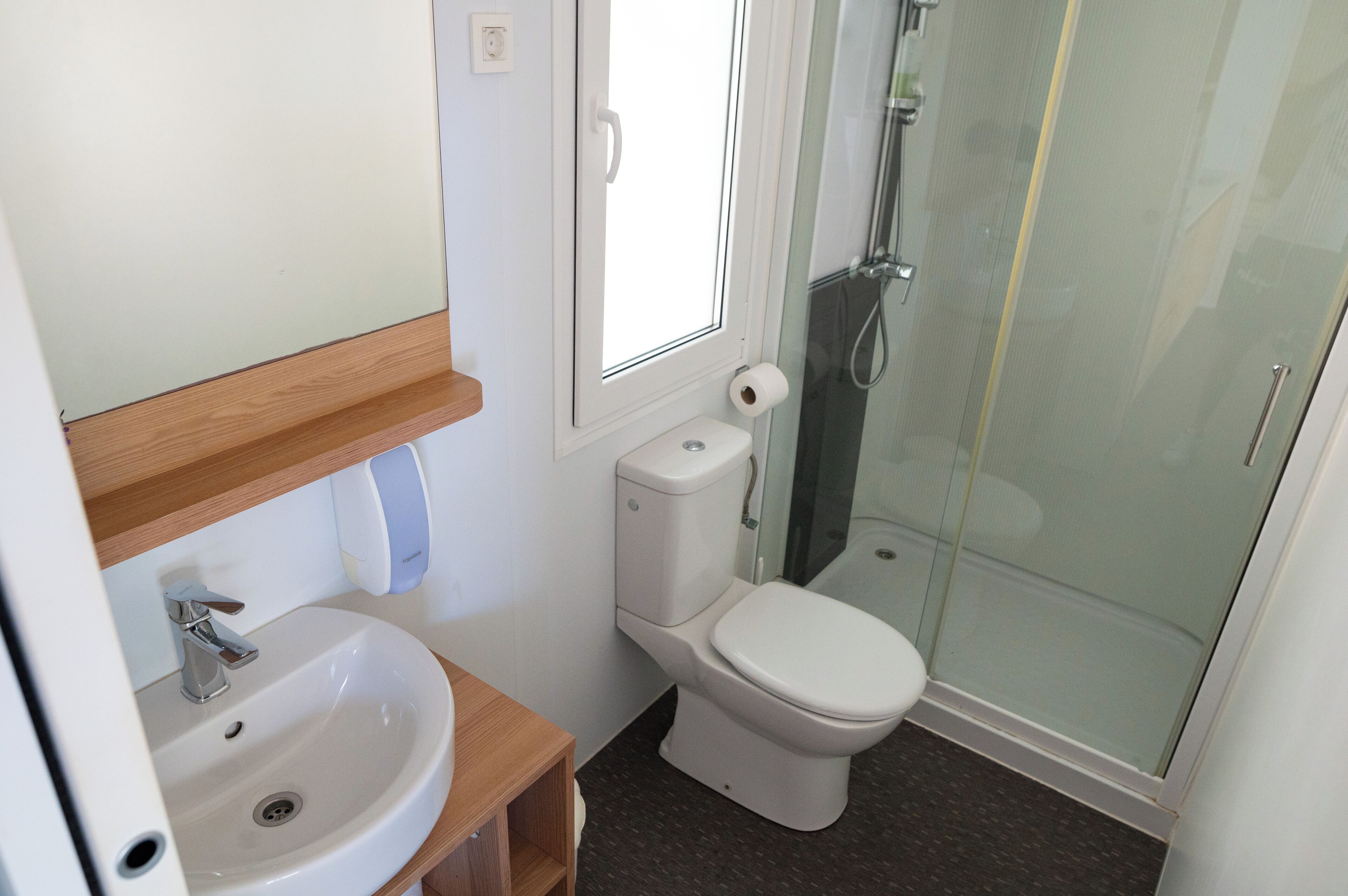 A bathroom with a sink, toilet, and glass-enclosed shower.