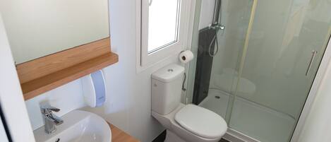 A bathroom with a sink, toilet, and glass-enclosed shower.
