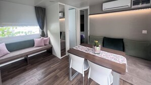 A compact RV interior with a dining area, a seating bench, and a kitchenette. - Camp Milo moje (Gradac)